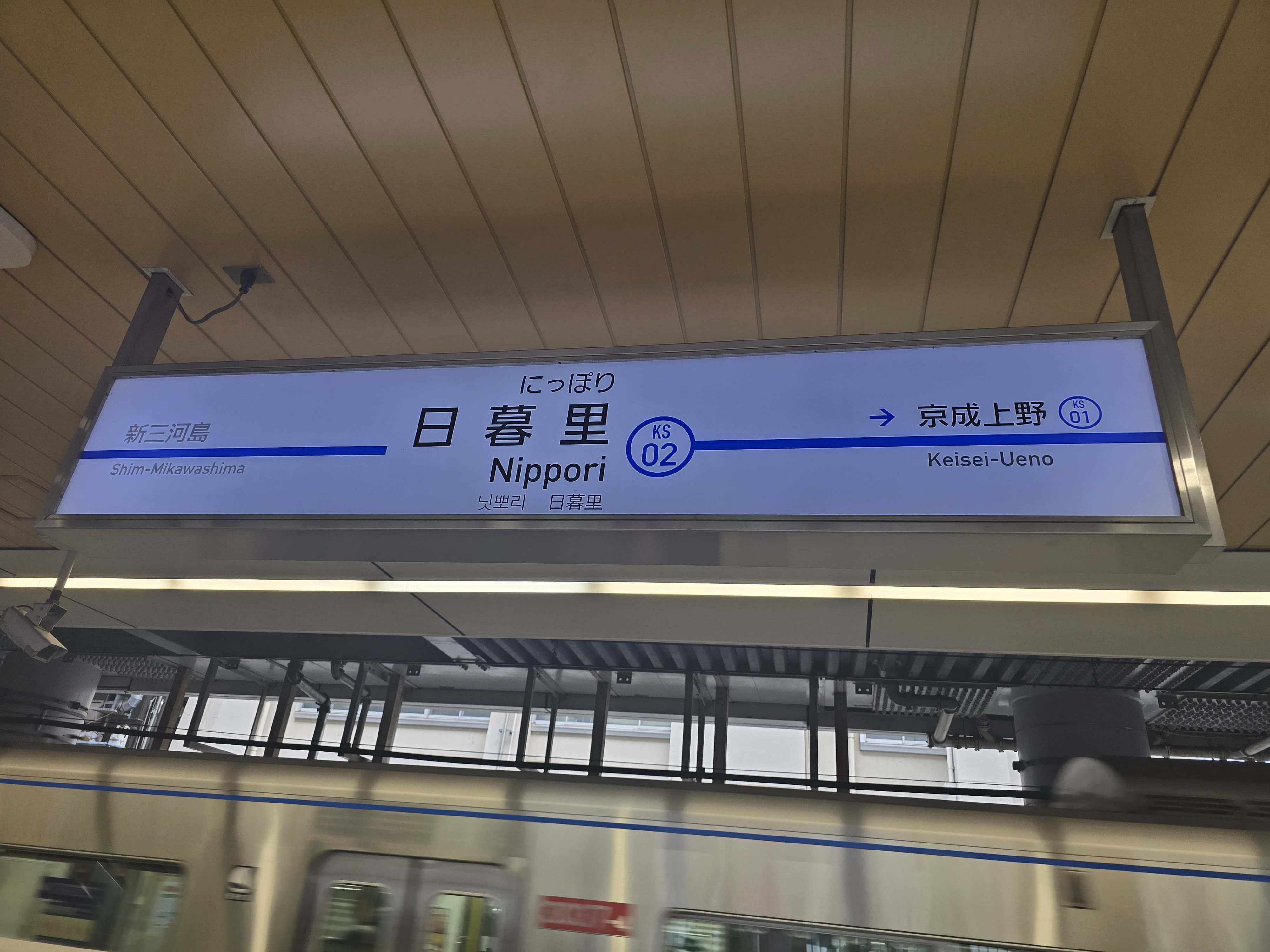京成线的日暮里站站牌，背后是京成本线的列车